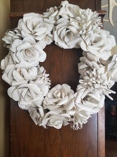 a wreath made out of old book pages sitting on top of a wooden door frame