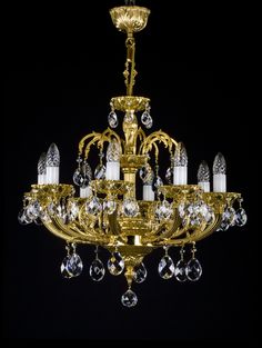 a gold chandelier with crystal drops hanging from it's center and sides