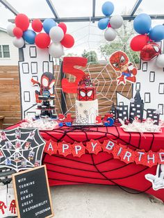 a spiderman themed birthday party with balloons and decorations