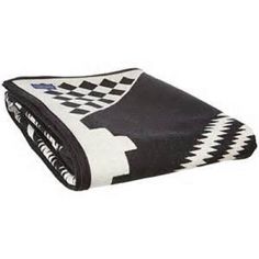 a black and white blanket folded up on top of a table with a checkerboard pattern