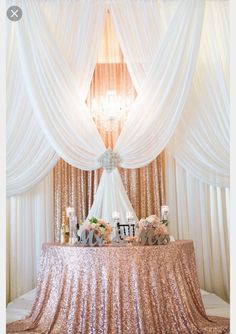 the table is covered with sequins and decorated with candles, flowers, and letters