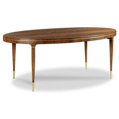 an oval wooden table with gold legs