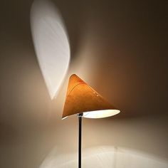 a lamp that is sitting on top of a wooden table next to a white wall