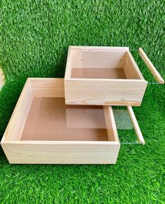 two wooden boxes sitting on top of green grass