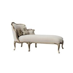 an antique chaise lounge chair with pillows on the back and arms, in white fabric