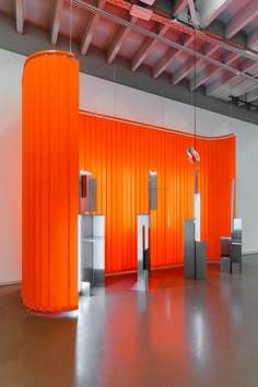 an empty room with orange walls and metal pillars