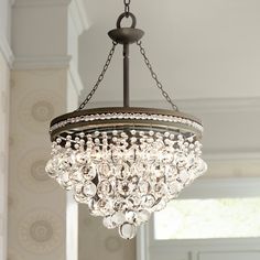 a chandelier hanging from the ceiling in a room with white walls and windows