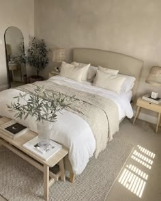 a bedroom with a bed, mirror and table in it