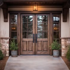 the front entrance to a home with two planters on either side of the door