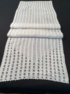 three pieces of white cloth on a black surface