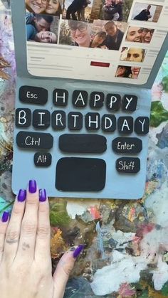 a woman's hand holding up a laptop computer with the words happy birthday on it