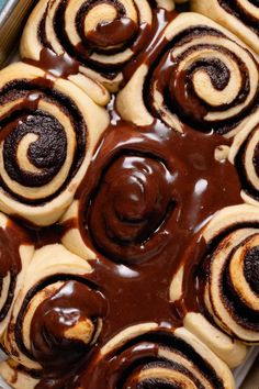 a pan filled with cinnamon rolls covered in chocolate