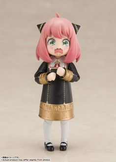 a doll with pink hair and green eyes is wearing a black coat, gold trimmings