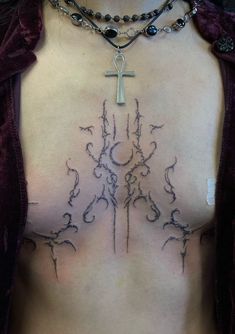 a woman's chest with a cross and vines on it