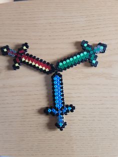 an airplane made out of beads sitting on top of a wooden table