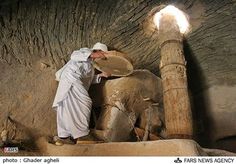 a man is washing an elephant's tusks in a stone room at the zoo