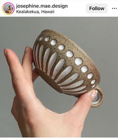 a hand holding a brown and white object in it's right hand, with the caption above it