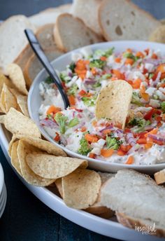 a bowl of dip with tortilla chips on the side