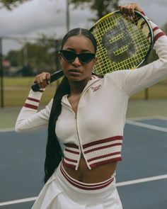 a woman holding a tennis racquet on top of a tennis court