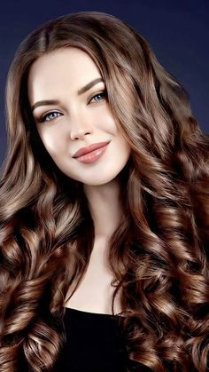 a woman with long, wavy hair is posing for the camera in front of a dark background