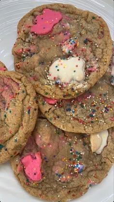 cookies with sprinkles and white frosting on a plate