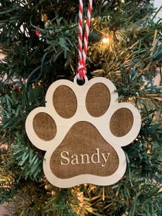 an ornament hanging from a christmas tree with a dog's paw on it