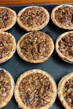 twelve pecan pies sitting on top of a baking sheet