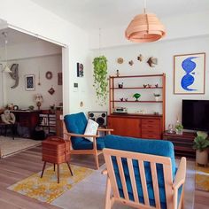 a living room filled with furniture and a flat screen tv sitting on top of a hard wood floor