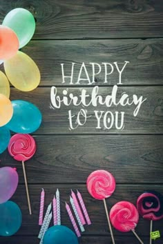 happy birthday to you card with lollipops and candies on wooden background