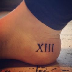 a person with a roman numeral tattoo on their foot