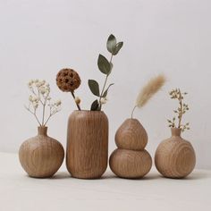 three wooden vases with flowers and plants in them