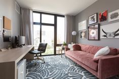 a living room filled with furniture and pictures on the wall next to a large window