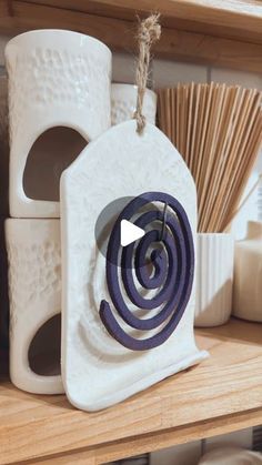 a white ceramic object with purple spirals on it