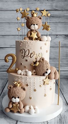 a two tiered cake with teddy bears on top