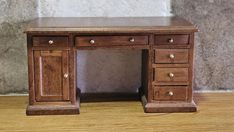 a small wooden desk with drawers on it