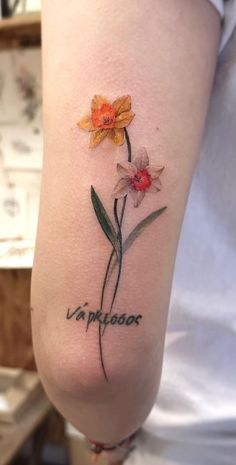 a woman with a tattoo on her arm that has flowers and the words la pliauxe written in cursive writing