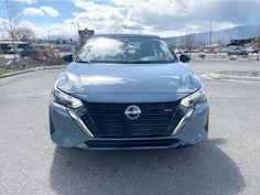 the front end of a blue car parked in a parking lot