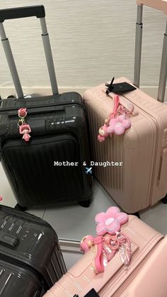 four pieces of luggage are sitting on the floor next to each other, one has a pink teddy bear attached to it