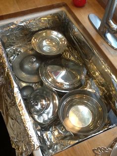 an open box filled with silverware on top of a wooden table