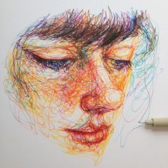 a pencil drawing of a woman's face with colored lines on the paper next to it