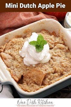 an apple pie in a baking dish with whipped cream on top and the title above it