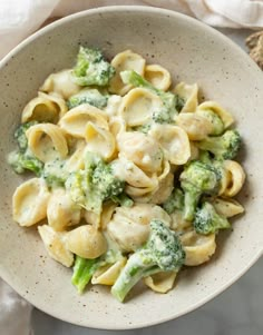 a white bowl filled with pasta and broccoli