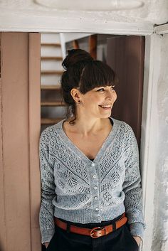 a woman standing in front of a window smiling