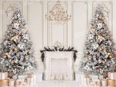 two decorated christmas trees in front of a fireplace