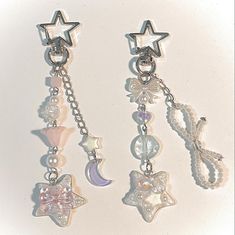 three charms are hanging from chains with stars and moon designs on them, along with beads