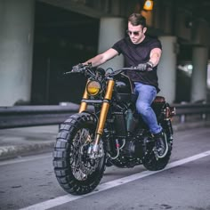 a man riding on the back of a motorcycle down a street