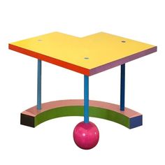 a colorful table with a pink ball in the middle and an upside down table on top