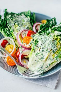 a salad on a plate topped with lettuce, tomatoes and other veggies