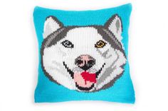 a knitted pillow with a dog's face on it