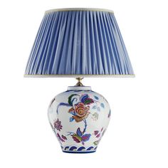 a lamp with a blue shade on top of it and a flower design on the bottom